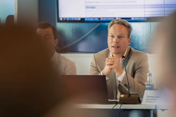 Speaker presenting at a corporate meeting in Barcelona, addressing an audience in a professional conference setting.